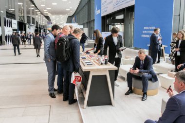 Masanın yanında cihazları olan insanlar.