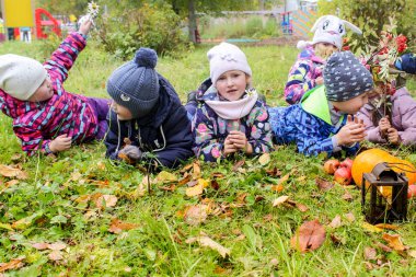 Bir grup çocuk çimlerin üzerinde yatıyor..
