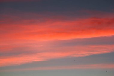 Gün batımında kırmızı bulutlar. Gökyüzündeki resim gibi bulutlar Güneş tarafından aydınlatılıyor.