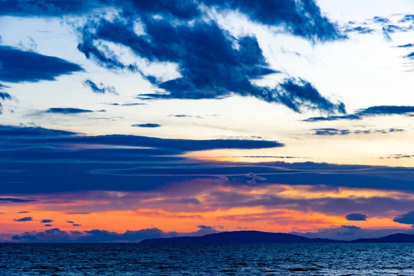 Sunset in Follonica viewing the Elba Island in late winter with cloudscape and shades of red