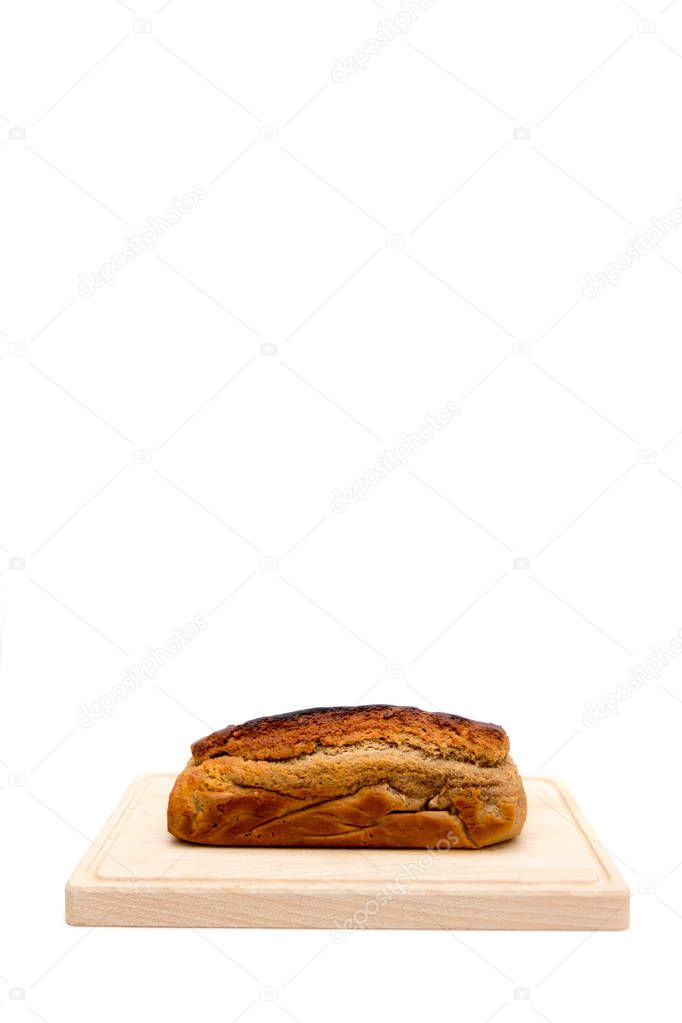 A homemade plumcake standing on a wooden board with a white background