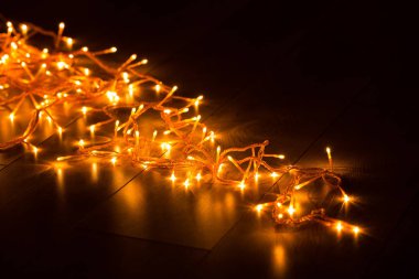 Ahşap arka plan üzerinde parlayan garland