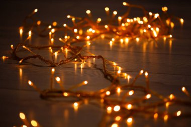 Ahşap arka plan üzerinde parlayan garland