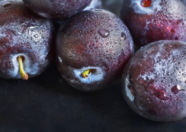 Su damlaları ile karanlık bir arka plan üzerinde Taze erik