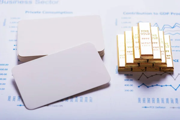 stack of  white blank business name card and gold bar on calendar background