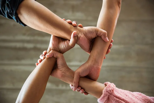 people join their hands together showing teamwork power