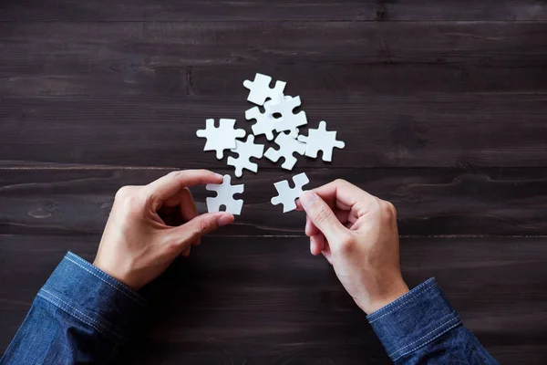 man hand connecting jigsaw puzzle pieces