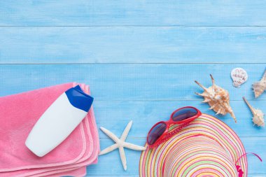 şapka, güneş gözlüğü, havlu ve yaz tatil zaman arka plan için ışık mavi ahşap tahta katta güneş kremi