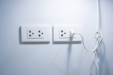 Beton duvarda beyaz elektrik prizi