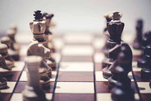 Чорний проти білих шахових фігур на шаховій дошці — стокове фото
