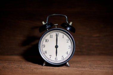 gündoğumu ışık ile ahşap masada siyah çalar saat