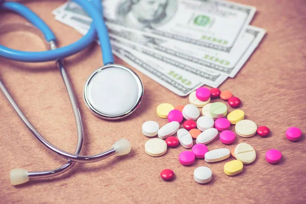 Stetoscopio e molti colori di pillole su sfondo di legno — Foto Stock