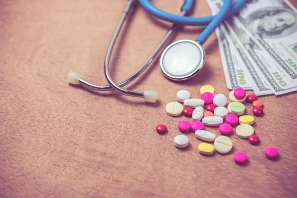 Stethoscope and many color of pills on wood background — Stock Photo, Image