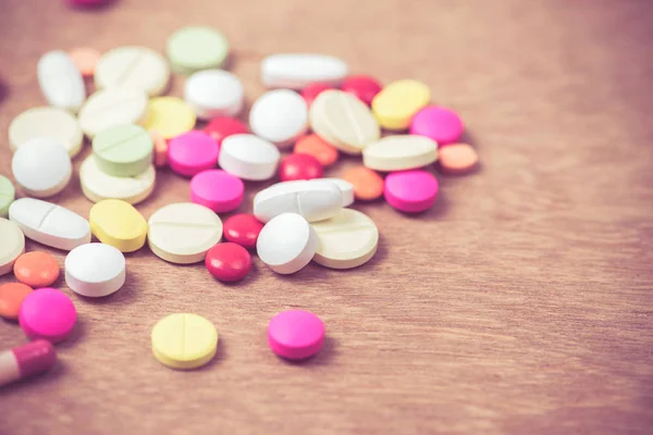 Molti colore di pillole su sfondo di legno — Foto Stock