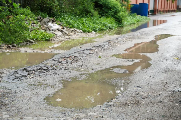 Regn vatten instängd i en ojämn väg — Stockfoto