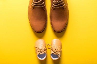 sarı arka planda Baba ve oğul ayakkabıları, baba gün kavramı