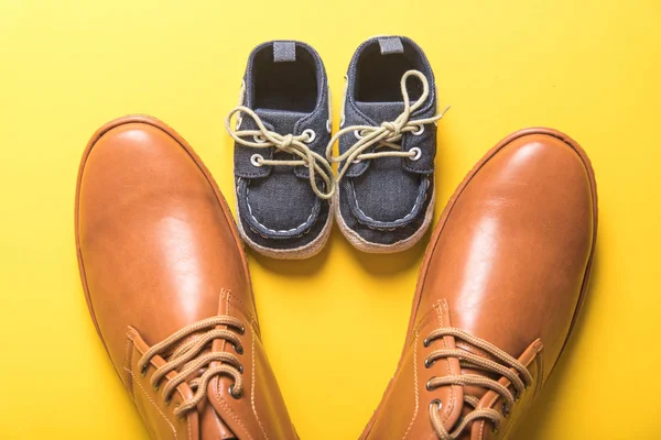 Far och son skor på gul bakgrund, fars dag koncept — Stockfoto