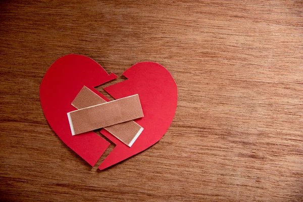 Papel vermelho coração partido no fundo de madeira, conceito de amor — Fotografia de Stock