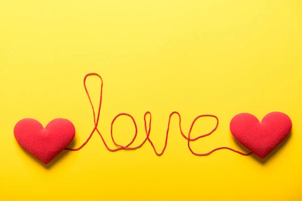 Two red heart and red string connect together on yellow paper ba — Stock Photo, Image