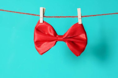 yeşil arka plan üzerinde clothespins ile asılı kırmızı yay ite