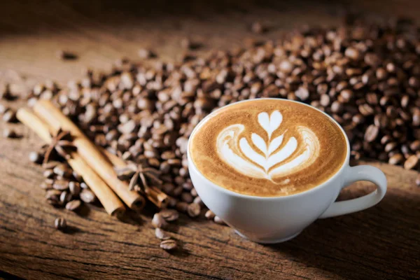 Vit kaffekopp och rostade kaffebönor runt — Stockfoto
