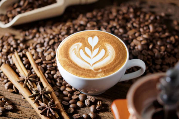 Xícara de café branco e grãos de café torrados ao redor — Fotografia de Stock