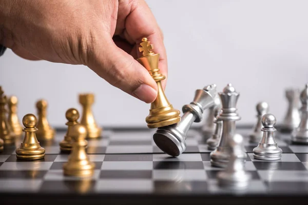 Чоловік обробляє золотий король шахи ліквідувати срібну шахову команду — стокове фото