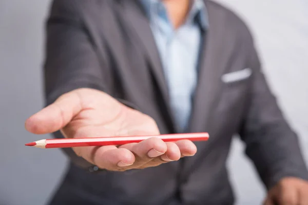 Hombre de negocios en traje dando lápiz de color rojo —  Fotos de Stock