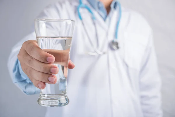 Dokter hand geven van een glas water — Stockfoto