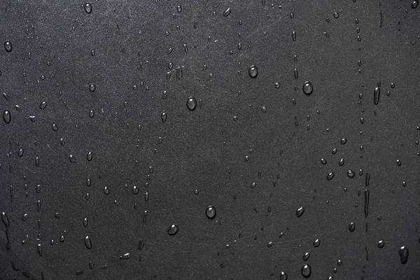 Kapka vody na černém povrchu — Stock fotografie