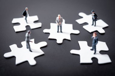 Minyatür iş adamı yapboz işini düşünüyor.