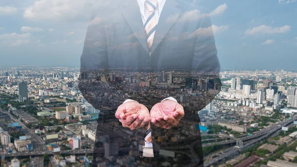 double exposure of businessman in black suite and cityscape background