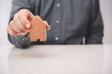 İş adamı beyaz masadaki tahta bloğu aldı.