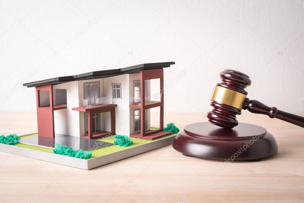 man hand holding gavel justice hammer and house model