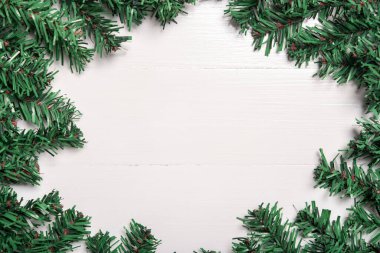 Yapay Noel ağacı yaprağı beyaz ahşap arka planda dekore edilir