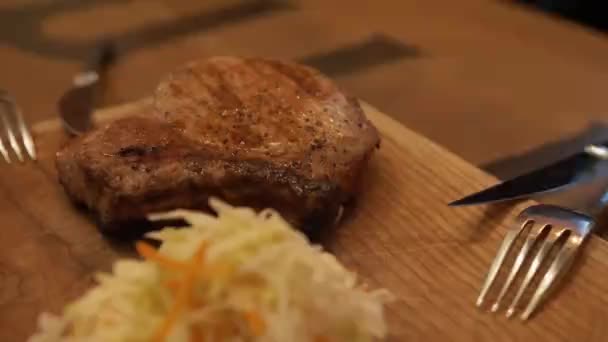 Filete cocido en una mesa de madera con ensalada de col — Vídeo de stock