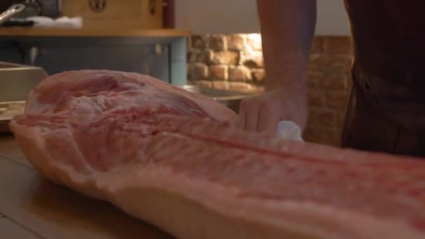 Schlachter wischt Schweinekadaver auf den Tisch — Stockvideo