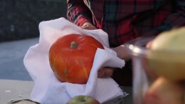Dámské ruce utírají dýni bílým ručníkem na trhu. Hygiena. — Stock video