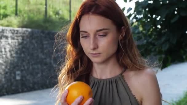 Joven bonita mujer oliendo naranja — Vídeo de stock