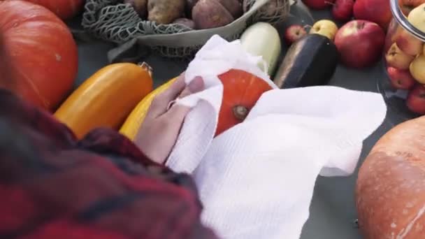 Les femmes essuient la citrouille avec une serviette blanche sur le marché. Vue de dessus. Hygiène. — Video