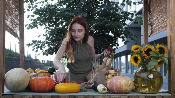 Jonge vrouw koopt rode hete chili pepers en zetten in de zak op de markt — Stockvideo