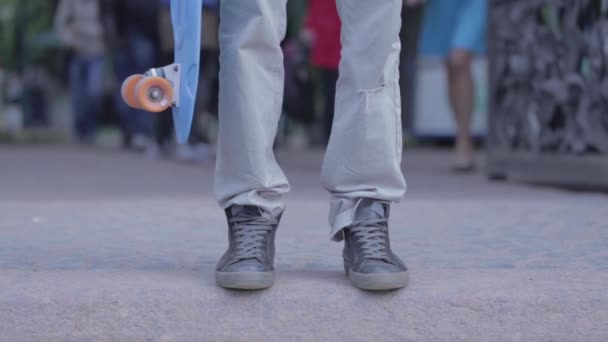 Mężczyzna Stoi Drodze Trzyma Łyżwy Rękach Ludzie Chodzą Kółko — Wideo stockowe