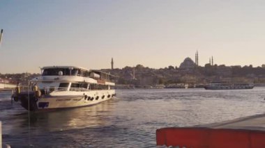 Gemi Altın Boynuz 'la rıhtımdan ayrılıyor. Martılar güneşli bir günde Rustem Paşa Camii üzerinde daireler çiziyor..