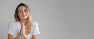 Yardım isteyen ve dua eden bir kadın, kameraya büyük umutla bakıyor, avuç içlerini bir arada tutuyor, ihanete uğramış erkek arkadaş olarak af diliyor, kendini suçlu hissediyor..