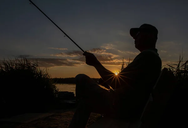 Silhouette Pescatore Tramonto Seduta Una Sedia Lunga Raggi Sole Taglienti — Foto Stock