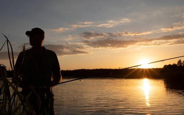 Silhouette Ψαρά Στο Ηλιοβασίλεμα Στέκεται Καλάμι Ψαρέματος Στη Λίμνη — Φωτογραφία Αρχείου