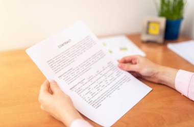 Ofisteki masadaki el işi kadını kapat. İş sözleşmesi kavramı okuma ve imzalama, işletme bürosu