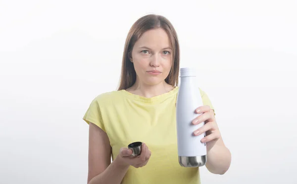 Jovem caucasiano mulher oferecer e dar eco garrafa de água pura ainda potável. Feminino segurando na mão água engarrafada isolada em um fundo branco. — Fotografia de Stock