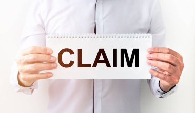 İş adamı elinde elinde yazılı bir kart tutuyor. Elinde iddia, dava ve iddia konsepti var.