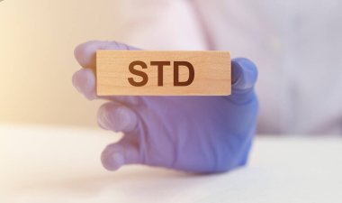 Tahta blok koruyucu doktor eldivenlerinde cinsel yolla bulaşan hastalık anlamına gelir. Tıbbi konsept. Doktor